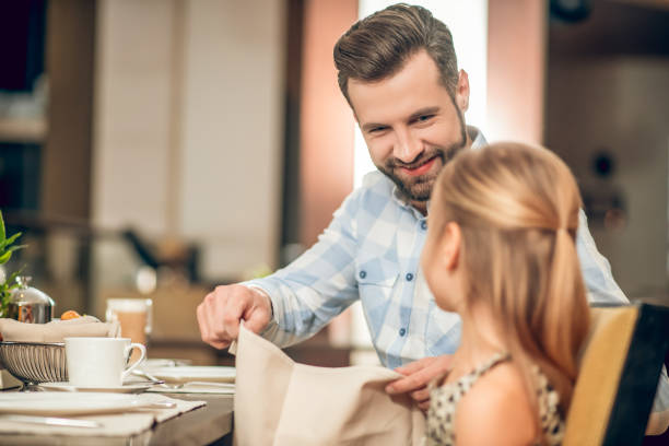 istock Dad having breakfast with his daughter and looking happy 1308845469