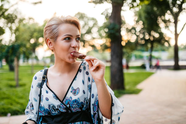 istock Woman eating ice-cream in park 1308846198