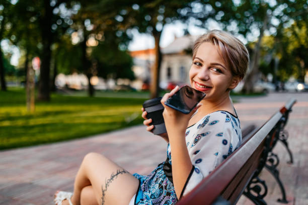 istock Woman sending voice message on phone in park 1308846336