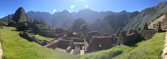 A wide panorama shot of the Machupiccu Inca ruins in the Cusco Region, Peru.