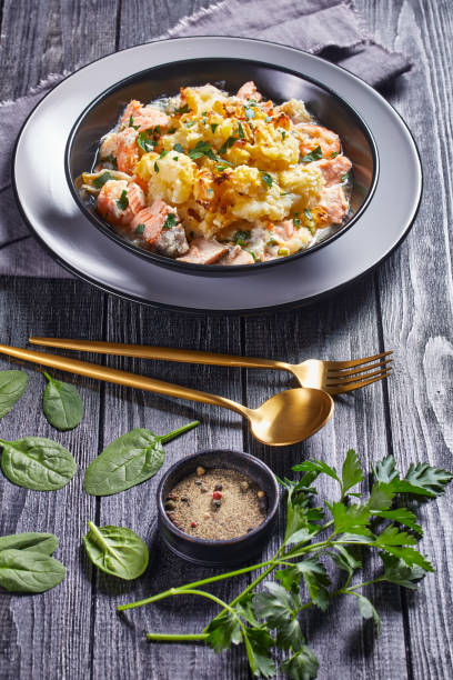 a portion of salmon pot pie with smoked haddock, prawns, spinach, topped with potato mash in a bowl, english cuisine a portion of salmon pot pie with smoked haddock, prawns, spinach, topped with potato mash in a bowl, english cuisine fish pie stock pictures, royalty-free photos & images