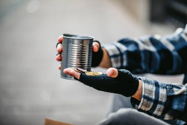 istock Beggar holding a can for money 1308847125
