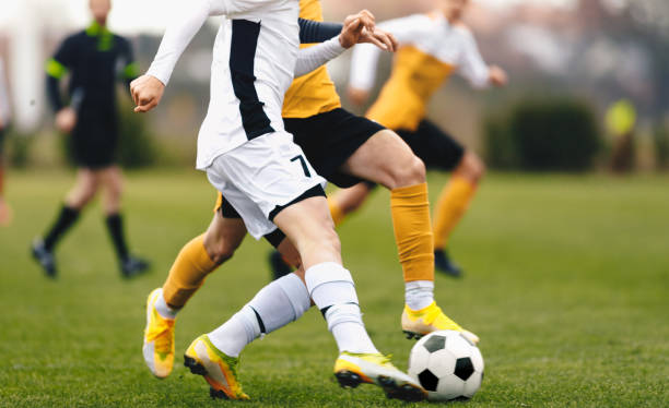 adult sports players in football duel run. footballers running ball at the game. youth soccer league competition match - soccer ball youth soccer event soccer imagens e fotografias de stock