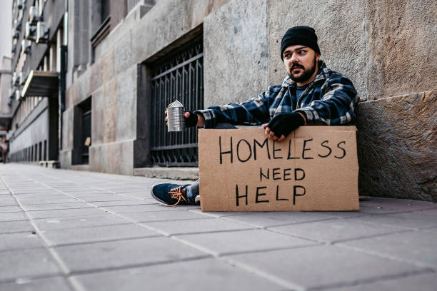 istock Homeless man sitting and begging for help 1308847822