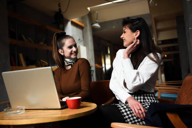 istock Two cheerful women having fun during coffee time in a cafe 1308849712