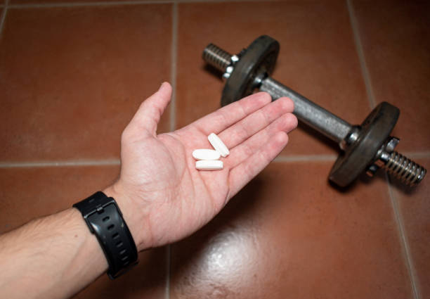 l-карнитин таблетки для похудения. концепция: фитнес дома - vitamin pill picking up pill capsule стоковые фото и изображения
