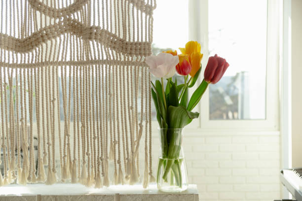 istock Beautiful spring multicolored tulips in a light interior next to macrame 1308854515