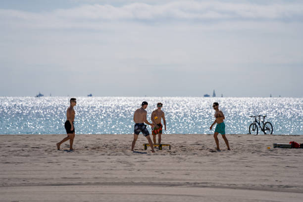 College guys playing spikeball on the beach during Spring Break Miami Beach FL Miami Beach, FL, USA - March 20, 2021: College guys playing spikeball on the beach during Spring Break Miami Beach FL decoteau stock pictures, royalty-free photos & images