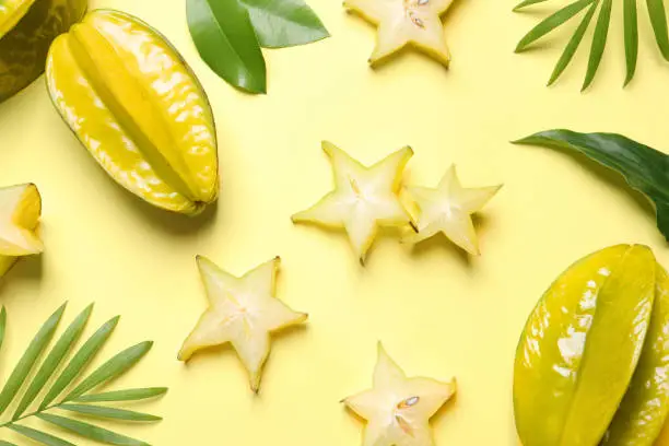 Delicious carambola fruits on yellow background, flat lay