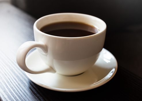 a white cup of coffee on a white saucer