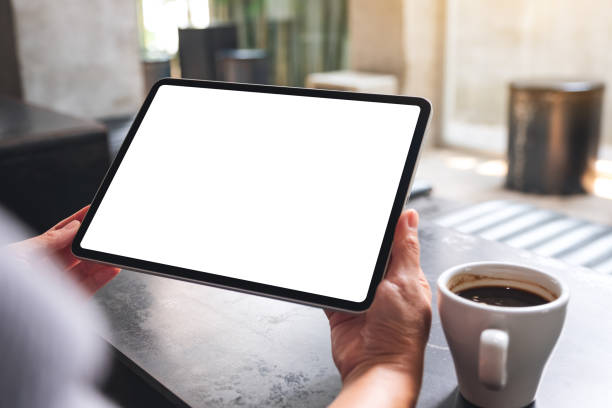 istock a woman holding digital tablet with blank white desktop screen in cafe 1308859805