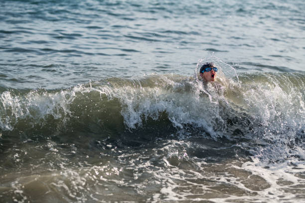 istock Little boy splashed by wave in the Tuscan sea 1308860650