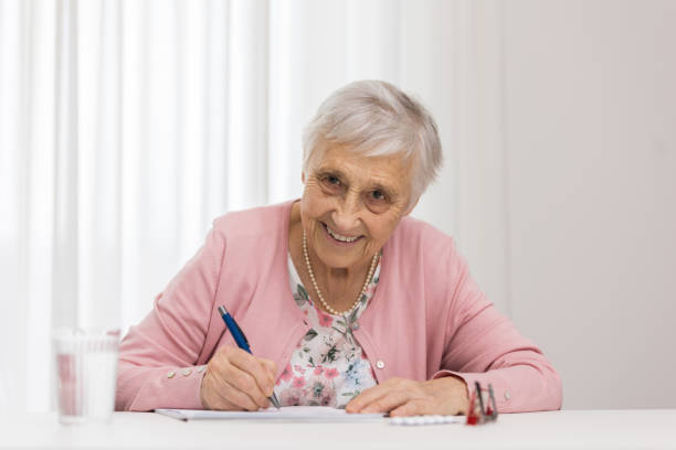 istock Elderly woman signs a document 1308860859