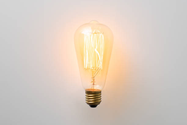 vintage light bulb glows without wires on white background stock photo