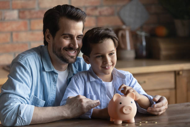istock Happy young father and little son save money 1308861337