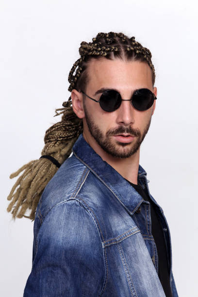 attraktive blonde männliche modell mit kombination von zöpfen und dreadlocks posiert im studio auf isolierten hintergrund. - young men men blond hair attractive male stock-fotos und bilder