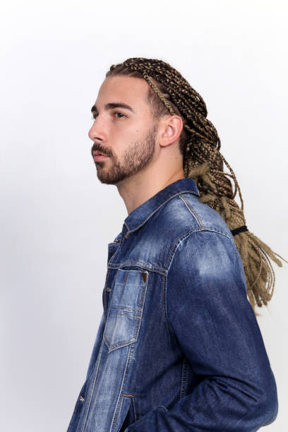 istock Attractive blonde male model with combination of braids and dreadlocks posing in studio on isolated background. 1308863603