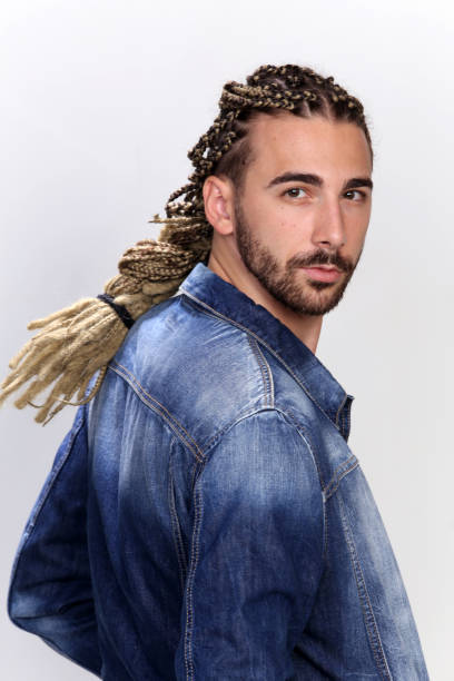 istock Attractive blonde male model with combination of braids and dreadlocks posing in studio on isolated background. 1308863637