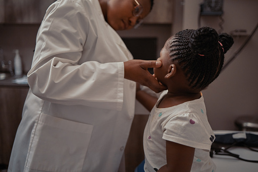 Shot of a doctor examining an adorable little girl in her consulting room