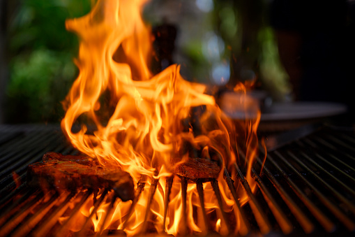 Close-up of a raw seasoned beef steak grills over a flaming barbecue grill, Nikon Z7