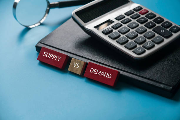 istock Supply vs demand concept with notebook,magnifying glass and calculator on blue background. 1308867089