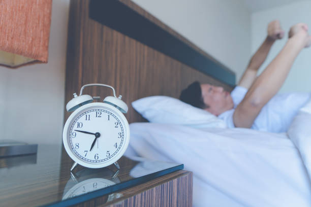 istock Young man stretching while waking up in the morning. Man yawning while waking up. Lazy young man in sleep. man yawns 1308867726