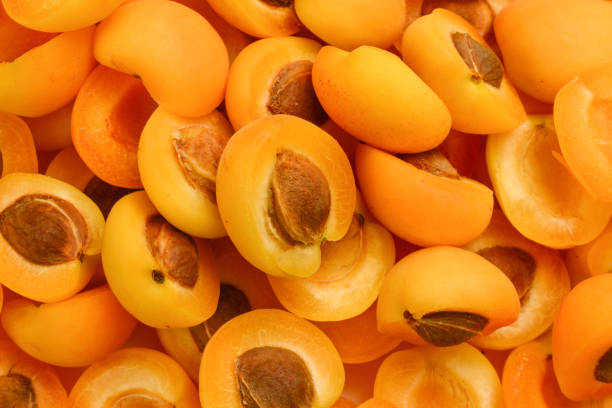 istock Ripe juicy orange apricots slices fruit background. 1308867796