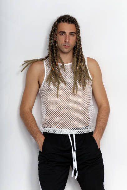 istock Attractive blonde male model with combination of braids and dreadlocks posing in studio on isolated background. 1308870270