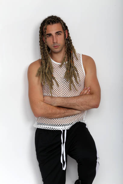 istock Attractive blonde male model with combination of braids and dreadlocks posing in studio on isolated background. 1308870302