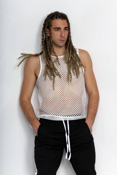 istock Attractive blonde male model with combination of braids and dreadlocks posing in studio on isolated background. 1308870313