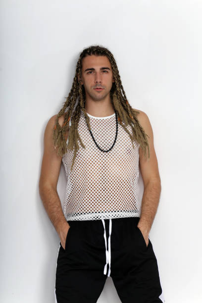 istock Attractive blonde male model with combination of braids and dreadlocks posing in studio on isolated background. 1308870418