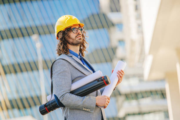 istock Architect in protective helmet in front of building 1308870979