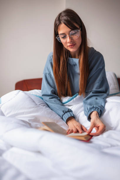 istock Woman reading a book at home 1308871497