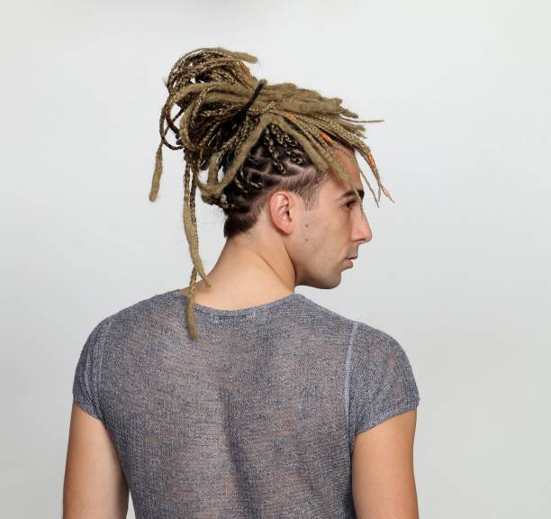 attraktive blonde männliche modell mit kombination von zöpfen und dreadlocks posiert im studio auf isolierten hintergrund. - young men men blond hair attractive male stock-fotos und bilder