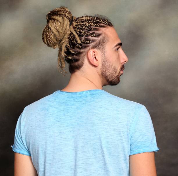 attraktive blonde männliche modell mit kombination von zöpfen und dreadlocks posiert im studio auf isolierten hintergrund. - young men men blond hair attractive male stock-fotos und bilder