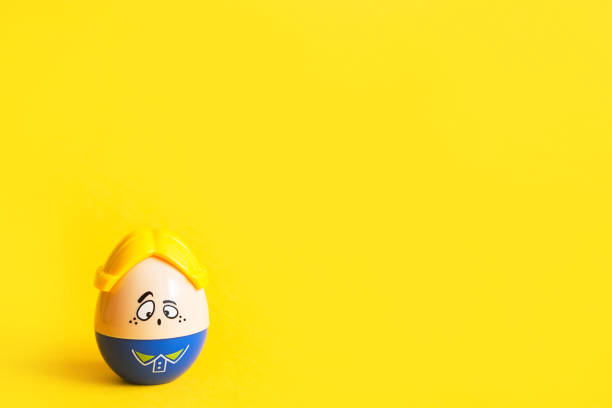 istock Funny egg toy with a man's sad face on a yellow background. Easter, solitude. Copy space 1308874205