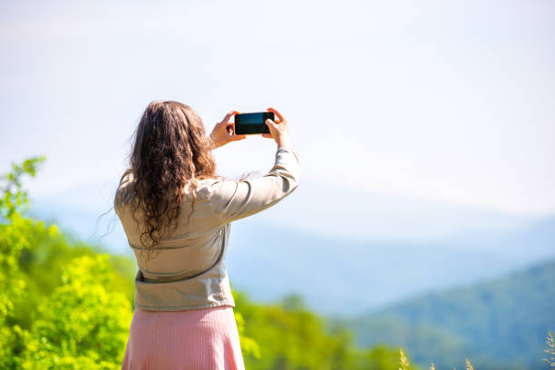 giovane donna in piedi a scattare foto selfie di vista sulle montagne appalachi shenandoah blue ridge con sfondo bokeh di picco - blue ridge mountains appalachian mountains appalachian trail skyline drive foto e immagini stock