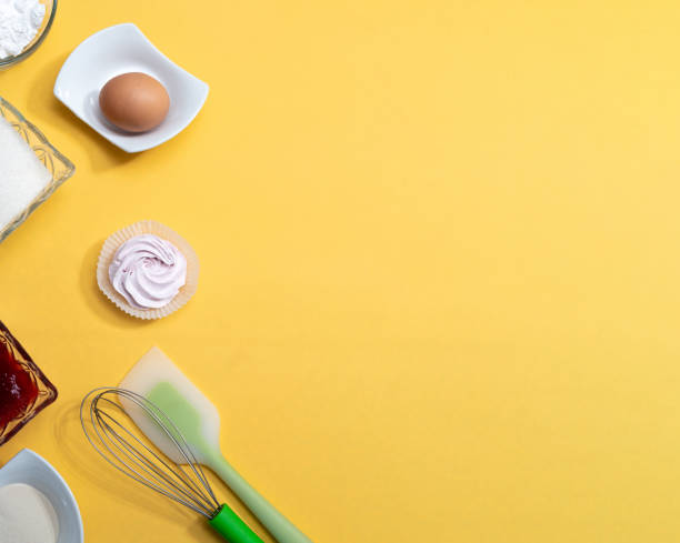 istock Ingredients with tools for making marshmallows. Sugar, jam, flour, whisk, spatula, marshmallow, egg on a yellow background with space for text. Selective focus. 1308874950