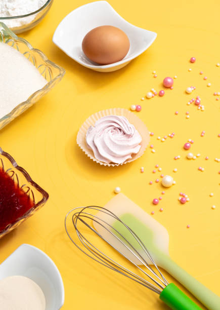 istock Ingredients with tools for making marshmallows. Sugar, jam, flour, whisk, spatula, marshmallow, egg and jelly beans on a yellow background. Selective focus. 1308875155
