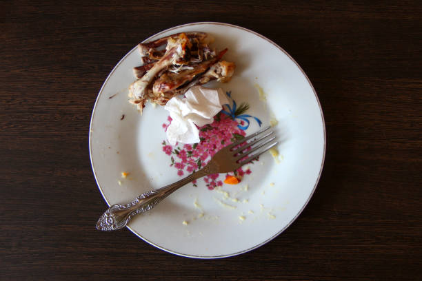 istock Dirty plate with a chicken bones after eating, top view 1308875205