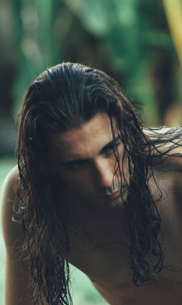 istock Attractive guy with very long hair is posing in the wild. 1308876319