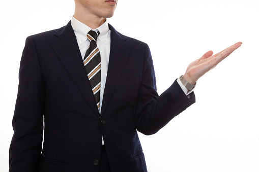 A business person who points forward with his left hand to talk and explain