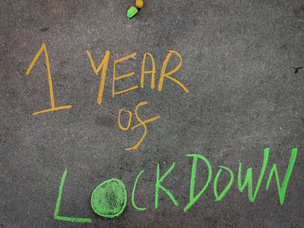 istock The inscription text on the grey board, One year of lockdown . Using color chalk pieces. 1308876559