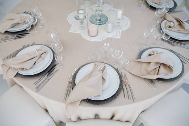 Festive wedding table setting with flowers, napkins, cutlery, glasses, bright summer table decor.