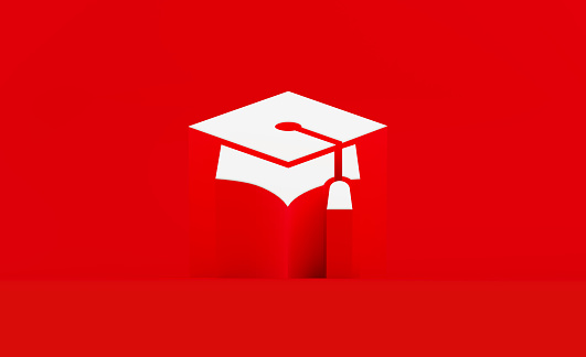 White mortarboard symbol sitting on red background. Horizontal composition with copy space. Online learning and graduation concept.