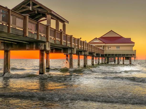 Clearwater Beach Pier at Sunset over ocean waves stock photo