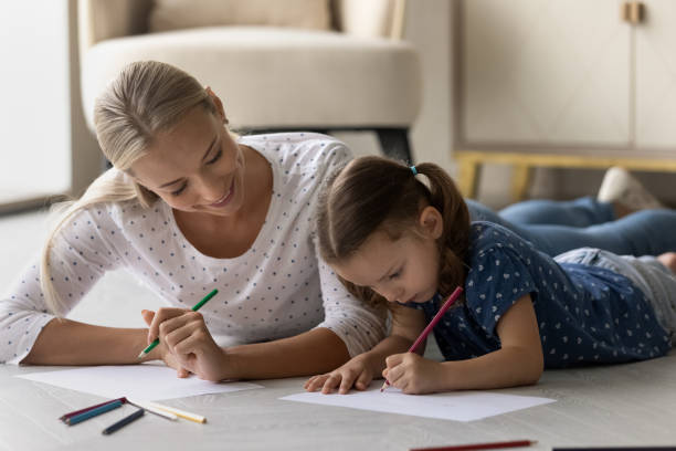 istock Happy young mom and small daughter drawing 1308881069