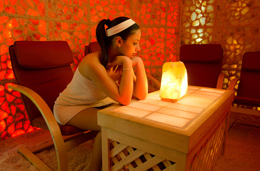 Young woman receiving Himalayan salt therapy in the salt room.