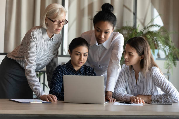 istock Multiracial female employees work together on laptop in office 1308883974