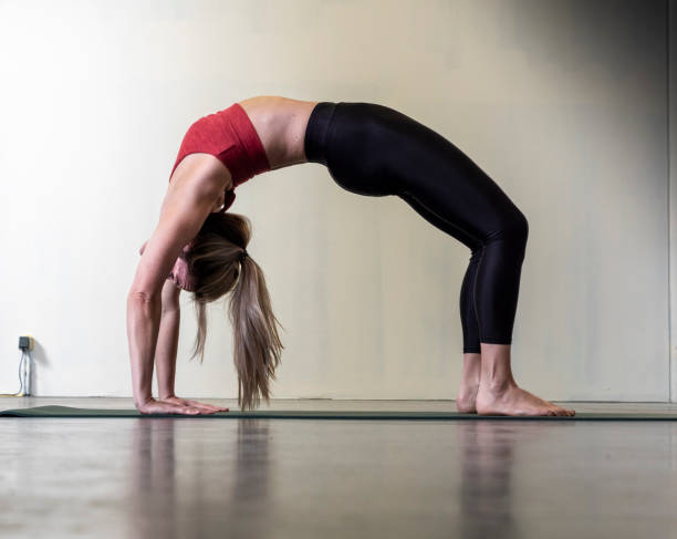 istock Blond female yoga instructor doing yoga bridge pose 1308885365
